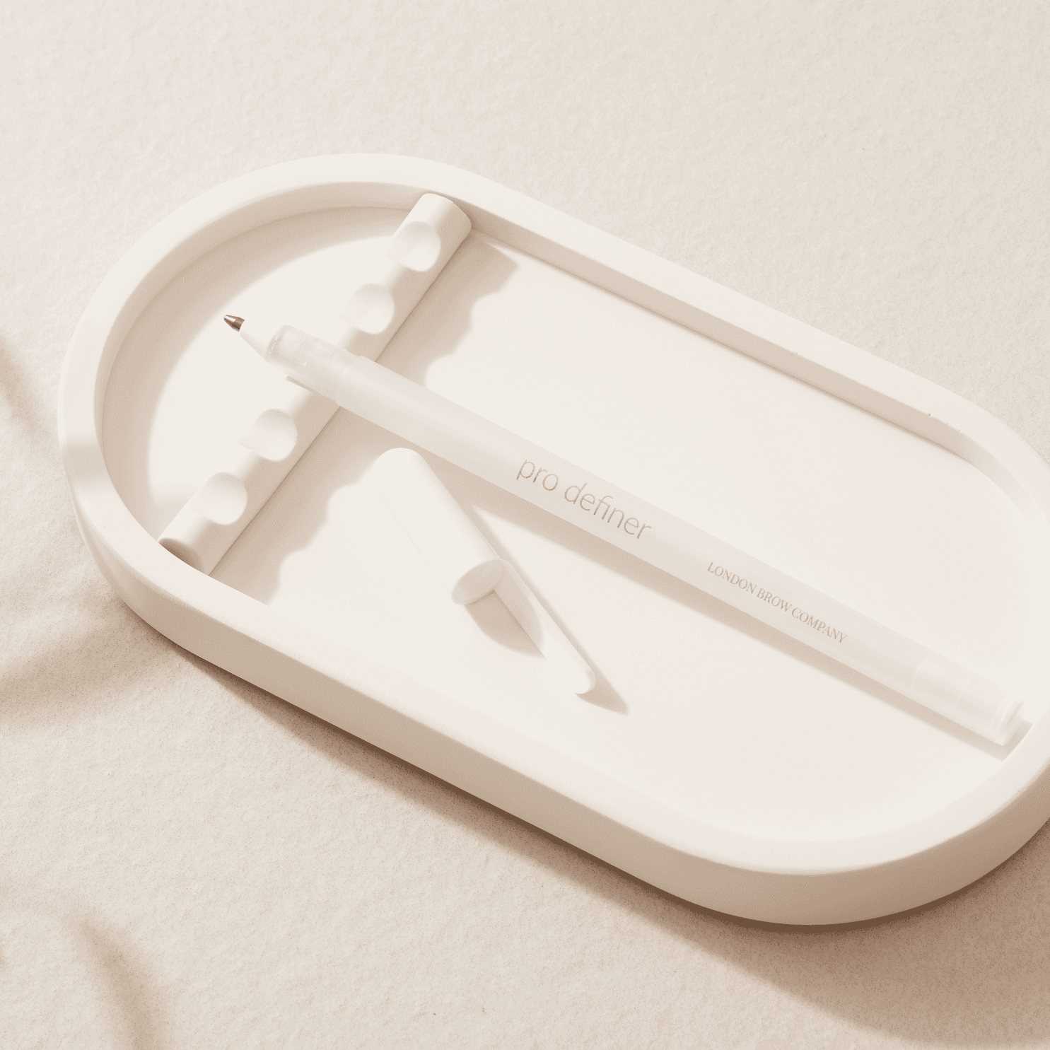 white eyebrow mapping pen from london beauty company on a jesmonite tray